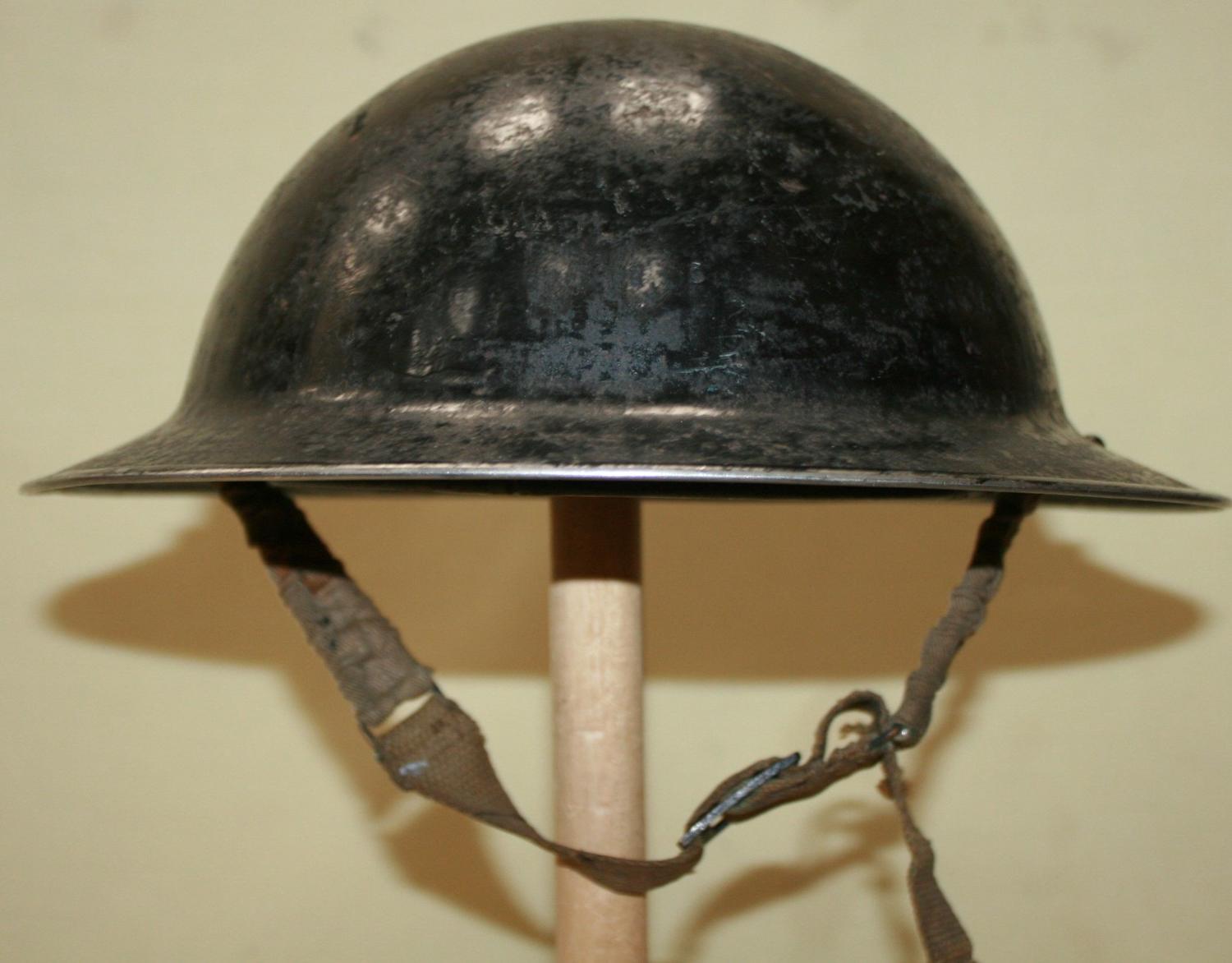 A 1939 DATED BLACK WARDENS HELMET SIZE 6 3/4