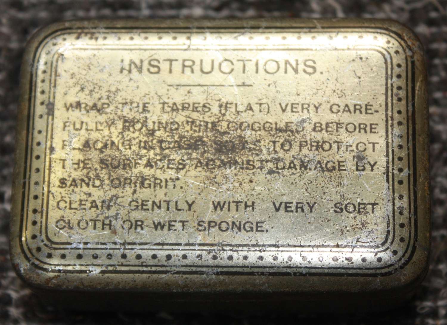 A PAIR OF WWII ORANGE TINTED GOGGLES CONTAINED IN THERE METAL TIN