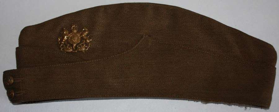 A GOOD WWII BRITISH ISSUE ARMY SIDE CAP NAMED AND BADGED